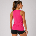 A woman shown from the back wearing a bright pink sleeveless athletic tank top and black athletic shorts against a light gray studio background.