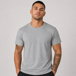 A man wearing a light gray crew-neck t-shirt, standing against a neutral light gray background.