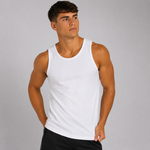 A man wearing a plain white sleeveless tank top and black shorts, standing against a light gray studio background.