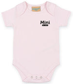 Light Pink baby onesie with short sleeves, featuring the text 'Mini Est. 2021' in Black on the left chest area and snap closures at the bottom