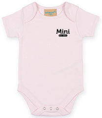 Light Pink baby onesie with short sleeves, featuring the text 'Mini Est. 2021' in Black on the left chest area and snap closures at the bottom