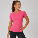 A woman wearing a bright pink short-sleeve athletic crewneck t-shirt and black leggings, posing against a light grey studio background.