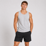 A man modeling a light gray sleeveless tank top and black athletic shorts against a plain light gray studio background.