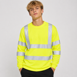 A young man wearing a bright neon yellow long-sleeve high-visibility work shirt with reflective silver stripes, paired with black pants, against a light gray studio background.