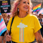 A woman at a pride parade wearing a bright yellow t-shirt with a cloud and rainbow graphic. She is holding a transgender pride flag, with a transgender pride sign and rainbow flags in the background.