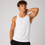 A man wearing a plain white sleeveless tank top and black shorts, posing against a light gray studio background.