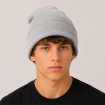 A young man wearing a light grey ribbed knit beanie hat and a black t-shirt, photographed against a neutral light grey background.