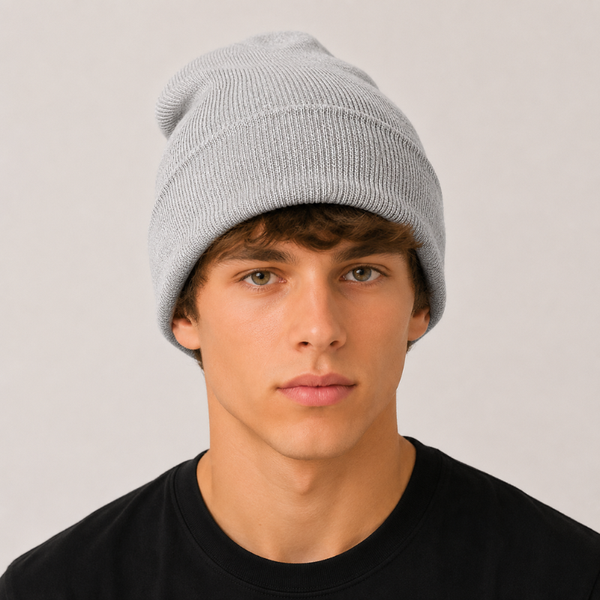 A young man wearing a light grey ribbed knit beanie hat and a black t-shirt, photographed against a neutral light grey background.