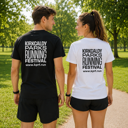 Two people standing on a park path wearing matching graphic t-shirts with the text 'KIRKCALDY PARKS RUNNING FESTIVAL www.kprf.run.