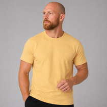 A man wearing a plain short-sleeve crewneck t-shirt in a solid pale yellow color, photographed against a neutral gray studio background.