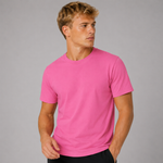 A man wearing a bright pink short-sleeve crewneck t-shirt, photographed against a solid grey studio background.