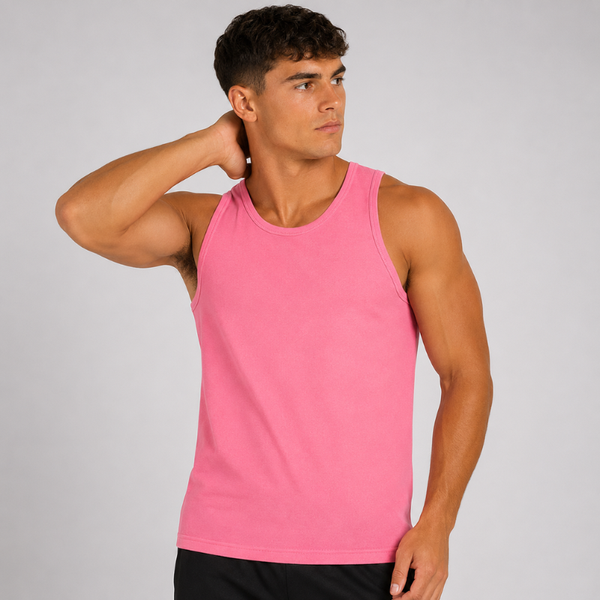 A man wearing a bright pink sleeveless tank top, posing with one arm raised against a plain light gray studio background.