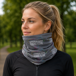 A woman wearing a grey neck gaiter with 'Kirkcaldy Parks Running Festival' printed on it, photographed outdoors with a blurred green park background.