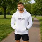 A man wearing a white hoodie with a colourful 'Kirkcaldy Downs Running Festival' graphic stands on a paved path in a park, wearing black athletic shorts.