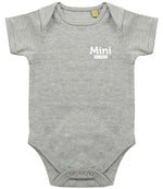 Grey baby onesie with short sleeves, featuring the text 'Mini Est. 2021' in white on the left chest area and snap closures at the bottom.