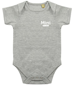 Grey baby onesie with short sleeves, featuring the text 'Mini Est. 2021' in white on the left chest area and snap closures at the bottom.