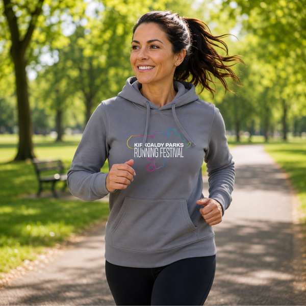 A woman jogging outdoors on a park path wearing a heather grey hoodie with a colourful graphic and the text 'KIF GALDY PARKS RUNNING FESTIVAL' on the chest.