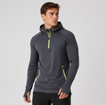 A man wearing a dark gray athletic pullover hoodie with bright neon green accents on the zipper and side pockets, photographed against a light gray studio background.