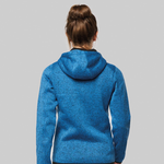 A woman viewed from behind wearing a heathered blue hooded sweatshirt against a solid grey background.