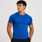 A man wearing a bright royal blue short-sleeve athletic t-shirt, paired with black shorts, photographed against a clean light gray studio background.