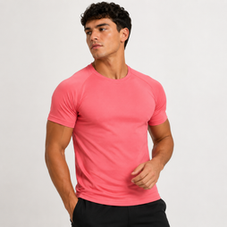 A man wearing a bright coral pink short-sleeve athletic t-shirt and black pants, standing against a light gray studio background.