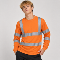 A young man wearing a bright orange long-sleeve high-visibility work shirt with reflective silver stripes, paired with black pants, against a light gray studio background.